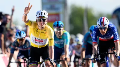 Winner Tadej Pogacar, left, from Slovenia, celebrates ahead of second placed Dorion Godon, right, from France, to win the second stage, a 173,1 km race between Rue and Vucherens, of the 79th Tour de Romandie UCI World Tour Cycling race, in Vuillens, Switzerland, Thursday, April 30, 2026. (Laurent Gillieron/Keystone via AP)