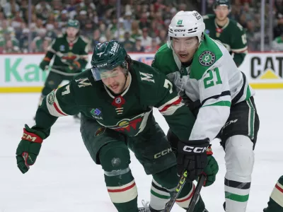 Minnesota Wild defenseman Brock Faber (7) and Dallas Stars left wing Jason Robertson (21) battle for position during the second period of Game 6 in the first round of the NHL hockey Stanley Cup playoff series Thursday, April 30, 2026, in St. Paul, Minn. (AP Photo/Bailey Hillesheim)