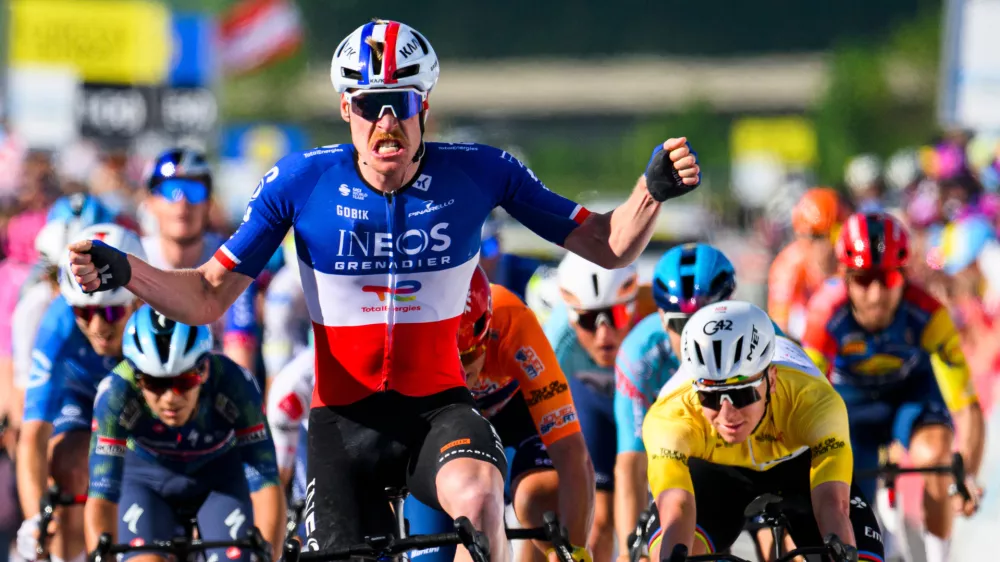 Dorion Godon, center, from France, raises his arms after crossing the finish line to win the third stage, a 176,6 km race around Orbe at the 79th Tour de Romandie UCI World Tour Cycling race, in Orbe, Switzerland, Friday, May 1, 2026. (Jean-Christophe Bott/Keystone via AP)