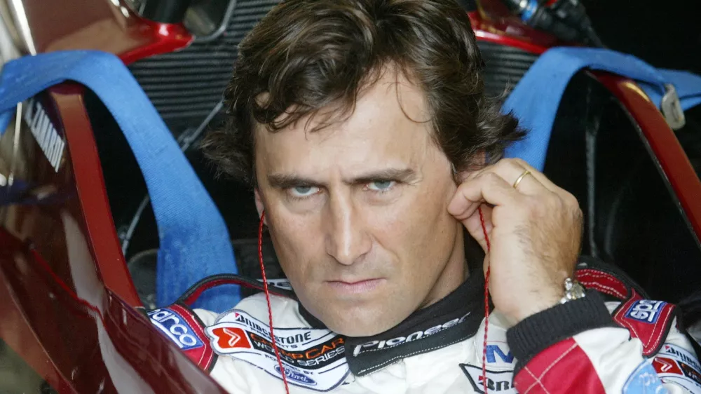 FILE PHOTO: Italian driver Alex Zanardi uses his ear sticks before sitting in the cockpit of his specially modified car at the Eurospeedway Lausitzring circuit in the eastern German town of Klettwitz May 11, 2003, before the German 500 CART race. Zanardi returned on Sunday to the race track in Germany where he lost both legs in a crash two years ago. REUTERS/Fabrizio Bensch/File Photo