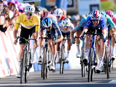 Winner Tadej Pogacar, left, from Slovenia, sprints ahead of second placed Dorion Godon, right, from France, to win the second stage, a 173,1 km race between Rue and Vucherens, of the 79th Tour de Romandie UCI World Tour Cycling race, in Vuillens, Switzerland, Thursday, April 30, 2026. (Laurent Gillieron/Keystone via AP)