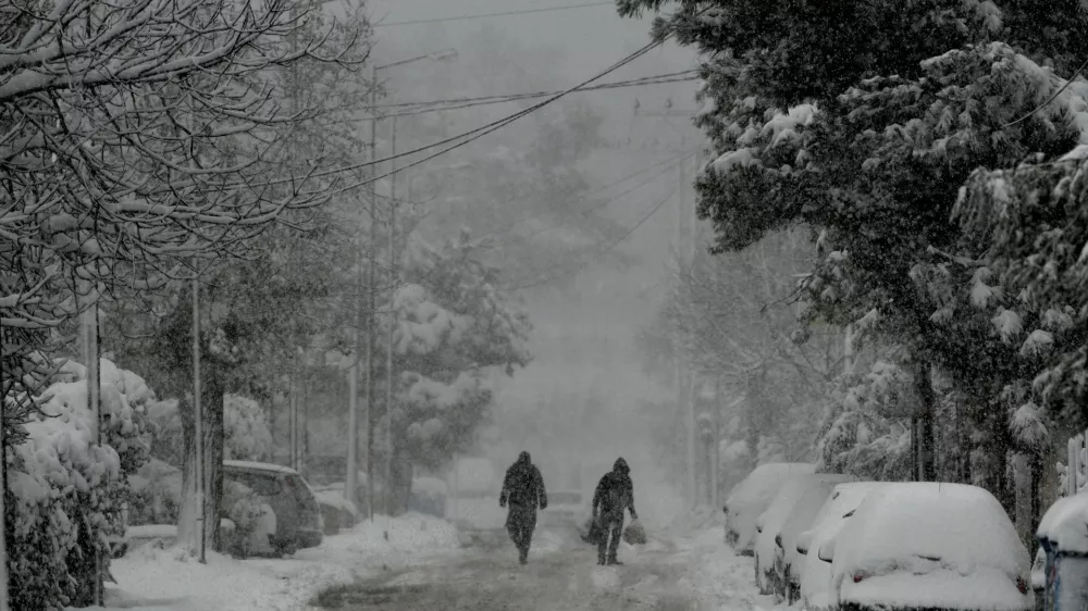 15 February 2021, Greece, Athens: People walk in a street covered with snow after strong winds and heavy snowfalls caused by the Medea storm which hit Greece. Photo: -/Eurokinissi via ZUMA Wire/dpa