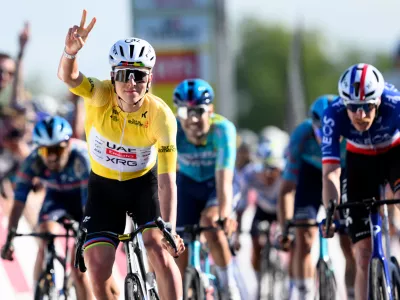 Winner Tadej Pogacar, left, from Slovenia, celebrates ahead of second placed Dorion Godon, right, from France, to win the second stage, a 173,1 km race between Rue and Vucherens, of the 79th Tour de Romandie UCI World Tour Cycling race, in Vuillens, Switzerland, Thursday, April 30, 2026. (Laurent Gillieron/Keystone via AP)