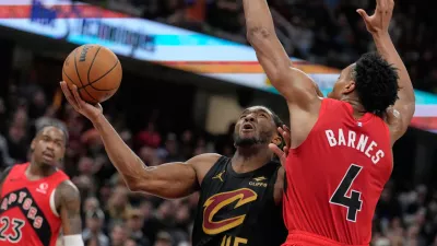 Cleveland Cavaliers guard Donovan Mitchell (45) goes up for a shot next to Toronto Raptors forward Scottie Barnes (4) in the second half in Game 7 of a first-round NBA basketball playoffs series in Cleveland, Sunday, May 3, 2026. (AP Photo/Sue Ogrocki)