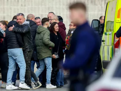 People react after a vehicle drove into a group of Belgian carnival performers who were preparing for a parade in the village of Strepy-Bracquegnies, Belgium March 20, 2022. REUTERS/Johanna Geron