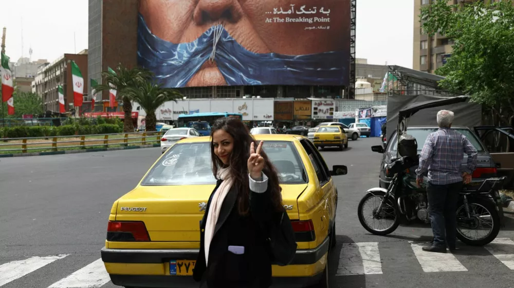 A woman gestures while walking near an anti-U.S. billboard depicting U.S. President Donald Trump and the Strait of Hormuz, in Tehran, Iran, May 4, 2026. Majid Asgaripour/WANA (West Asia News Agency) via REUTERS ATTENTION EDITORS - THIS PICTURE WAS PROVIDED BY A THIRD PARTY