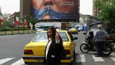 A woman gestures while walking near an anti-U.S. billboard depicting U.S. President Donald Trump and the Strait of Hormuz, in Tehran, Iran, May 4, 2026. Majid Asgaripour/WANA (West Asia News Agency) via REUTERS ATTENTION EDITORS - THIS PICTURE WAS PROVIDED BY A THIRD PARTY