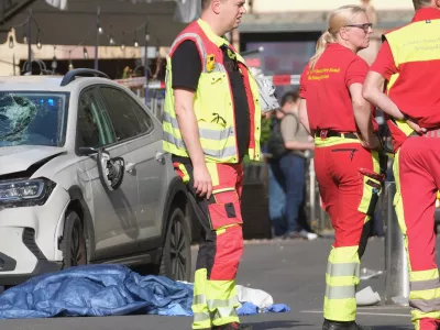 Rescue workers stand next to a damaged car that has crashed into several people in Leipzig, Germany, Monday, May 4, 2026. (Sebastian Willnow/dpa via AP)
