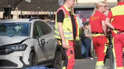 Rescue workers stand next to a damaged car that has crashed into several people in Leipzig, Germany, Monday, May 4, 2026. (Sebastian Willnow/dpa via AP)