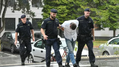 Emanuel Rep v spremstvu policistov na zaslišanje v Varaždinu. Sumijo ga umora mame s sekiro ter poskusa umorov polbrata in očima. 
