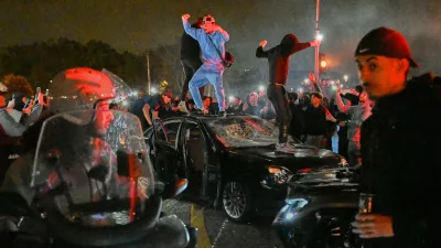 People smash a car as they celebrate Paris Saint-Germain's Champions League semifinal victory over Bayern Munich at Place de la Concorde in Paris, Thursday, May 7, 2026. (AP Photo/Emma Da Silva)