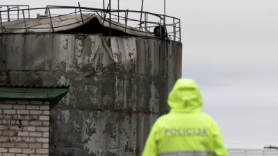 Police officer looks at damage to an oil tank after drones crashed at a storage facility in Rezekne, Latvia, May 7, 2026. REUTERS/Janis Laizans