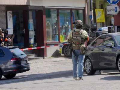 08 May 2026, Rhineland-Palatinate, Sinzig: Police officers stand at the scene. According to initial police reports, a hostage situation has occurred at a bank branch in Sinzig, Rhineland-Palatinate. The emergency services are on the scene with a large contingent in the Ahrweiler district. Photo: Thomas Frey/dpa,Image: 1097318057, License: Rights-managed, Restrictions: GERMANY OUT, Model Release: no