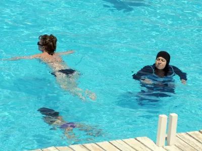 A woman wearing a swimming outfit that covers her body swims at the pool of a hotel in the Tunisian coastal holiday city of Mahdia, on August 31, 2012. According to some local media, fewer women go to the beach wearing bikinis as they fear attacks by religious extremists after the Islamist Ennahda party came to power following the uprising which toppled president Zine el Abidine Ben Ali.,Image: 140650482, License: Rights-managed, Restrictions:, Model Release: no