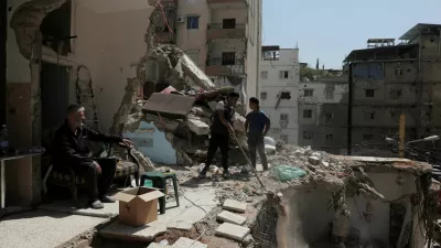 Ali Soueidan, 60, from southern Lebanon, looks at people cleaning his damaged house in the southern suburbs of Beirut, Lebanon, May 8, 2026. REUTERS/Raghed Waked