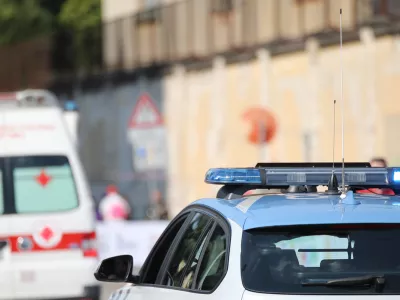 police car with blue flashing lights on it while escorting an ambulance to go to the hospital after the accident