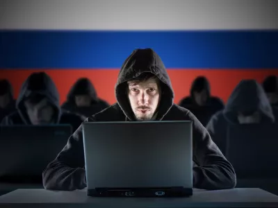 Many russian hackers in troll farm. Cyber crime and security concept. Russia flag in background.