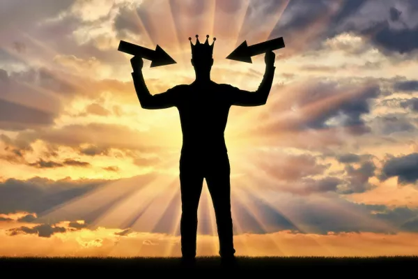 Silhouette of a selfish man with a crown on his head tries to attract attention by holding pointer in his hands. The concept of a selfish and narcissistic personality