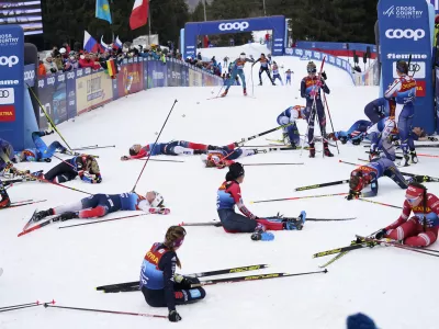 Participants recover at the finish line during the Women's Mass Start Free 10km event at the Tour de Ski in Val di Fiemme, Trento, Italy, Tuesday, Jan. 4, 2022. (AP Photo/Giovanni Auletta)