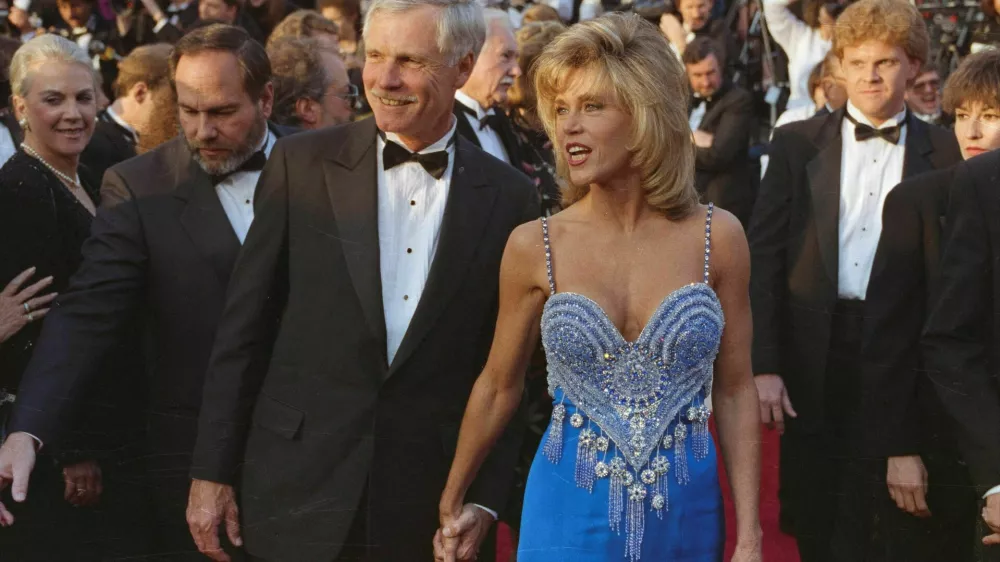 FILE PHOTO: Actor Jane Fonda and media mogul Ted Turner hold hands as they arrive at the Academy Awards in Los Angeles, California, U.S., March 26, 1990. REUTERS/Lee Celano/File Photo DISCLAIMER: The image is presented in its original, uncropped, and untoned state. Due to the age and historical nature of the image, we recommend verifying all associated metadata, which was transferred from the index stored by the Bettmann Archives, and may be truncated.