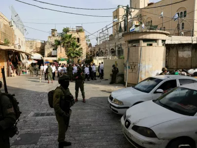 Israeli soldiers stand guard during a weekly settlers' tour in Hebron, in the Israeli-occupied West Bank, May 9, 2026. REUTERS/Mussa Qawasma