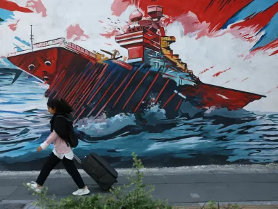 An Iranian woman walks next to a mural on a street in Tehran, Iran, May 11, 2026. Majid Asgaripour/WANA (West Asia News Agency) via REUTERS ATTENTION EDITORS - THIS PICTURE WAS PROVIDED BY A THIRD PARTY
