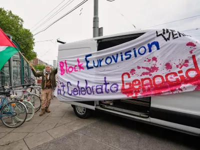 A man waves a Palestinian flag to protest against Israel ahead of the first semi-final of the 70th Eurovision Song Contest in Vienna, Austria, Tuesday, May 12, 2026. (AP Photo/Martin Meissner)