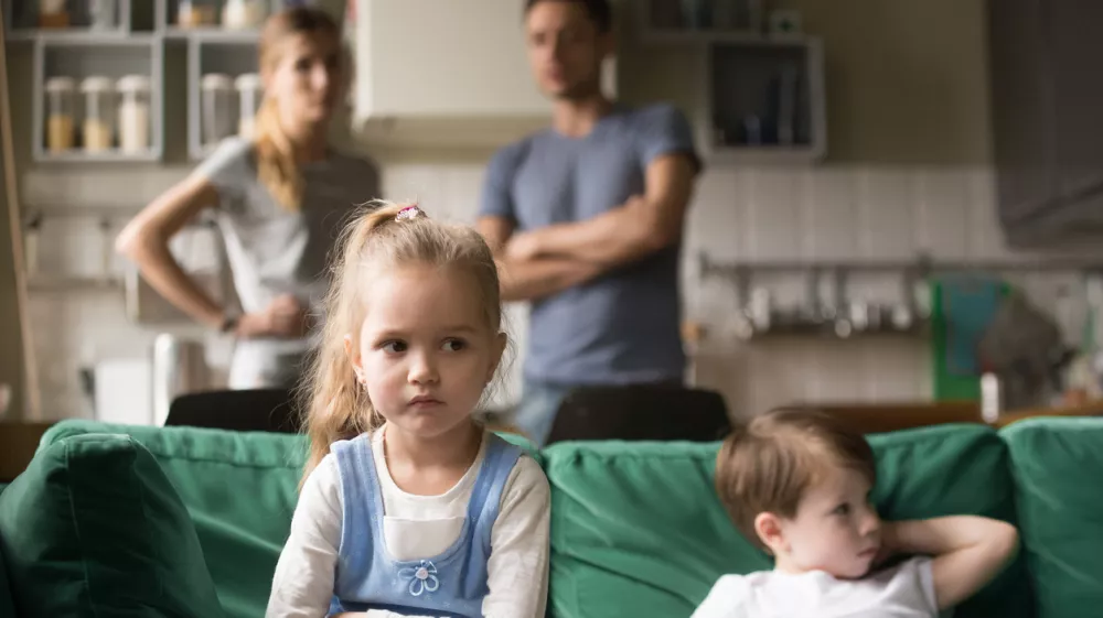 Frustrated kid girl feels upset, offended or bored ignoring avoiding worried parents and brother, little sad sister not talking to child boy after fight sulking sitting on couch, siblings rivalry