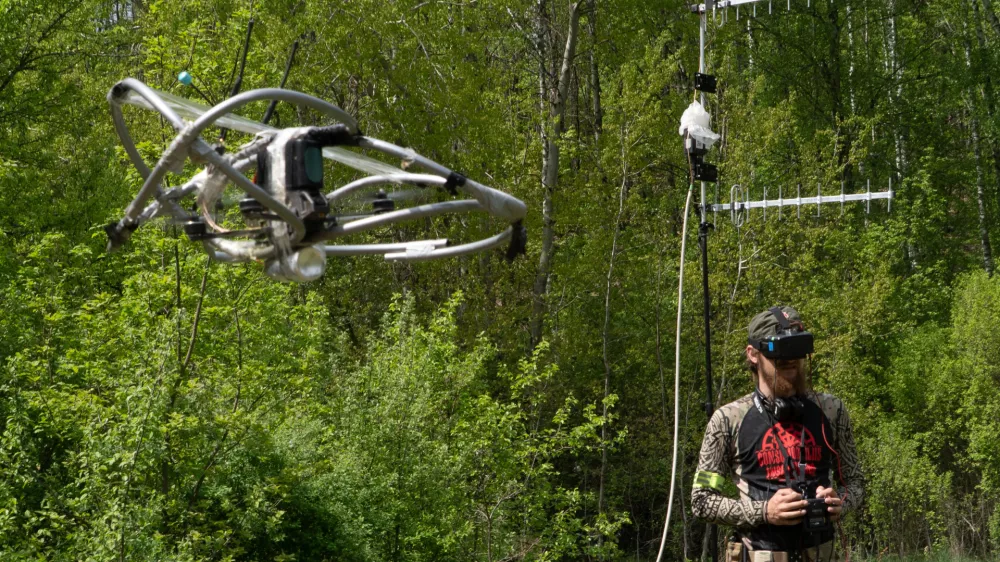 A recruit of Ukraine's 58th Mechanized Brigade practices military skills with an FPV drone at a training ground near the frontline in the Kharkiv region, Ukraine, Tuesday, May 12, 2026. (AP Photo/Andrii Marienko)