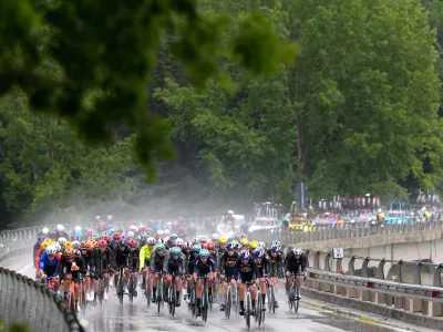The pack of riders pedals under pouring rain, during the fifth stage of the Giro d'Italia cycling race, from Praia a Mare to Potenza, Italy, Wednesday, May 13, 2026. (Fabio Ferrari/LaPresse via AP)