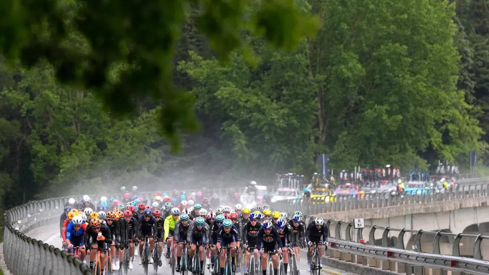 The pack of riders pedals under pouring rain, during the fifth stage of the Giro d'Italia cycling race, from Praia a Mare to Potenza, Italy, Wednesday, May 13, 2026. (Fabio Ferrari/LaPresse via AP)