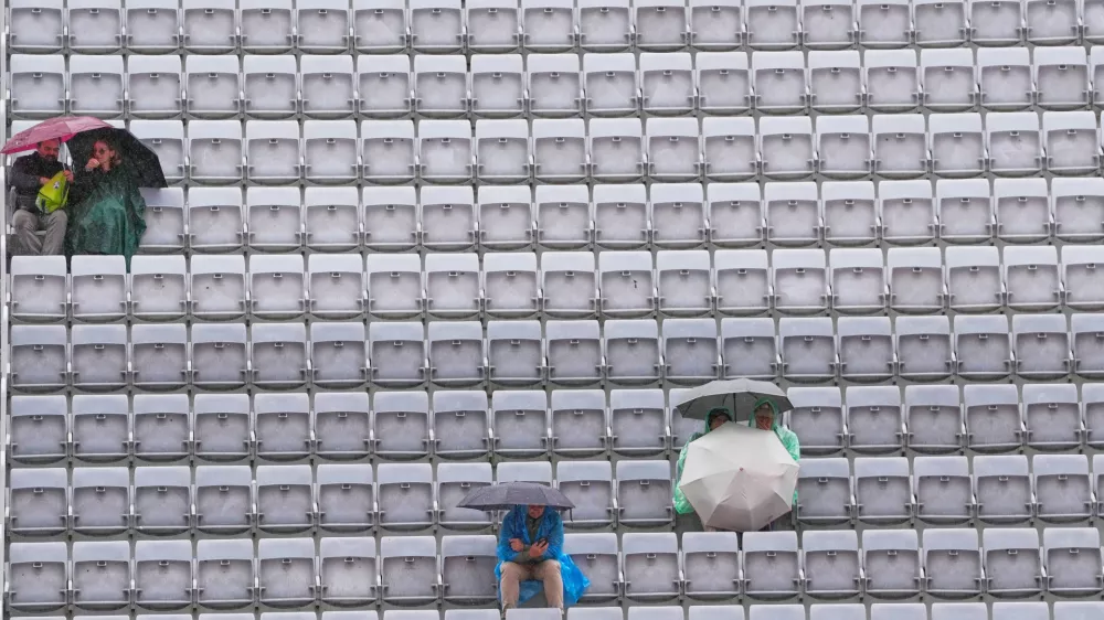 Spectators shelter with umbrellas as the quarter-final match between Karen Khachanov, of Russia, and Casper Ruud, of Norway, is suspended due to rain at the Italian Open tennis tournament in Rome, Wednesday, May 13, 2026. (AP Photo/Gregorio Borgia) / Foto: Gregorio Borgia