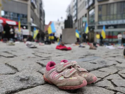 08 April 2023, Thuringia, Jena: Children's shoes are seen on the ground in a square in the city centre. With this action, women who fled from Ukraine want to collect donations for the parents of children killed in the war. Photo: Bodo Schackow/dpa
