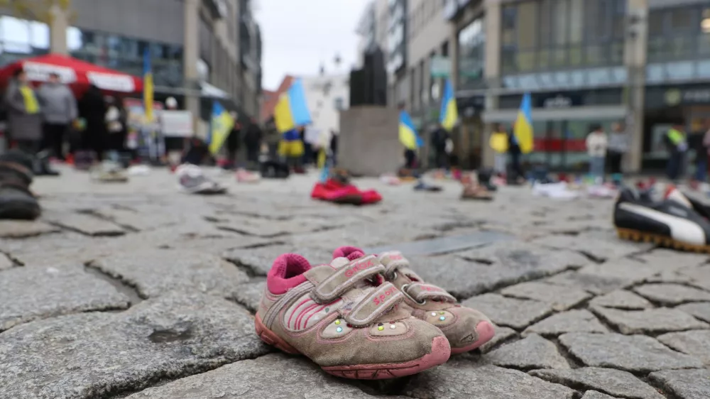 08 April 2023, Thuringia, Jena: Children's shoes are seen on the ground in a square in the city centre. With this action, women who fled from Ukraine want to collect donations for the parents of children killed in the war. Photo: Bodo Schackow/dpa