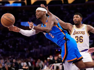 Oklahoma City Thunder guard Shai Gilgeous-Alexander, left, passes as Los Angeles Lakers guard Marcus Smart defends during the second half of Game 3 in a second-round NBA basketball playoffs series Saturday, May 9, 2026, in Los Angeles. (AP Photo/Mark J. Terrill)