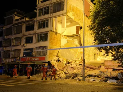 Rescue workers walk past a damaged building following an earthquake at Taiyang village in Liuzhou, Guangxi Zhuang Autonomous Region, China May 18, 2026. cnsphoto via REUTERS  ATTENTION EDITORS - THIS IMAGE WAS PROVIDED BY A THIRD PARTY. CHINA OUT. NO COMMERCIAL OR EDITORIAL SALES IN CHINA