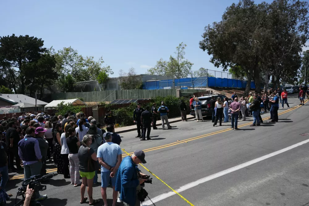 A crowd gathers near the scene of a shooting outside the Islamic Center of San Diego Monday, May 18, 2026, in San Diego. (AP Photo/Gregory Bull)