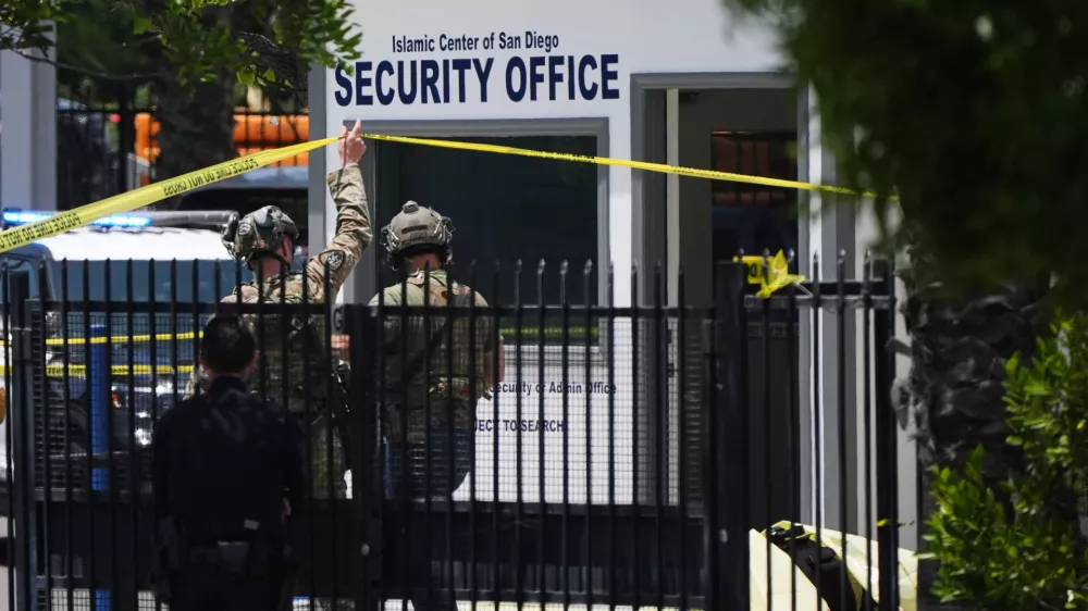 A body is covered with a tarp at the scene of a shooting outside the Islamic Center of San Diego Monday, May 18, 2026, in San Diego. (AP Photo/Gregory Bull)