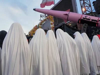 A group of girls stand beside a "Khaybar-buster" missile during a mass wedding ceremony for couples participating in the "Janfada" ("Sacrifice for Iran") pro-government campaign in Tehran, Iran, Monday, May 18, 2026. (AP Photo/Vahid Salemi)