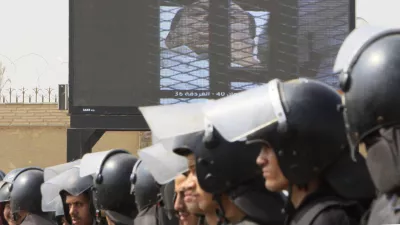Egyptian anti-riot soldiers line up under a giant screen showing former President Hosni Mubarak outside the police academy court in Cairo, Egypt, Monday, Aug. 15, 2011. Former President Hosni Mubarak returned to court Monday for the second session of his trial on charges of corruption and complicity in killing protesters during the mass uprising that ousted him from power. (AP Photo/Amr Nabil)