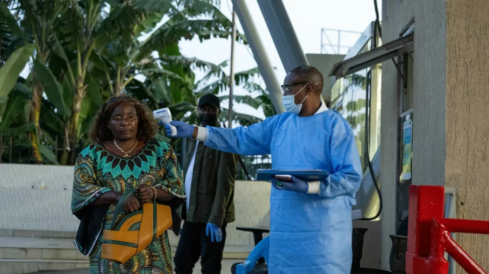 A Congolese health worker checks the temperature to screen a traveller at the Grande Barrier border following confirmation of an Ebola outbreak involving the Bundibugyo strain, at the border crossing point between Congo and Rwanda, in Goma, Democratic Republic of Congo May 18, 2026. REUTERS/Arlette Bashizi