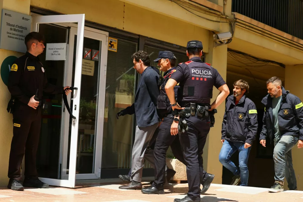 Jonathan Andic, the son of the founder of the Mango fashion group, Isak Andic, arrives at court escorted by police, where he is expected to be questioned after being detained in an investigation of the death of his father, who was killed in a fall from a cliff near Barcelona in December 2024, in Martorell, Spain, May 19, 2026. REUTERS/Albert Gea