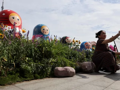 A person takes a selfie in front of Russian nesting dolls at the North Bund, ahead of Russian President Vladimir Putin's visit to China, in Shanghai, China, May 19, 2026. REUTERS/Go Nakamura