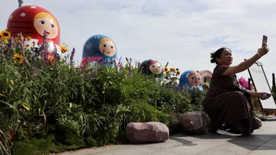 A person takes a selfie in front of Russian nesting dolls at the North Bund, ahead of Russian President Vladimir Putin's visit to China, in Shanghai, China, May 19, 2026. REUTERS/Go Nakamura