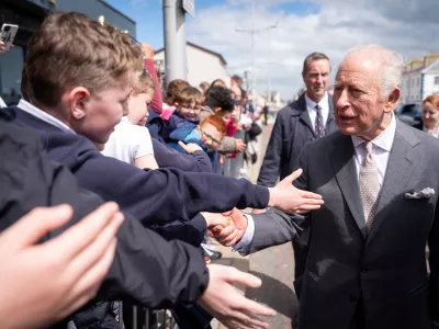 Britain's King Charles III, right, meets well-wishers outside The Pantry Foodbank in Donard Methodist Church, Newcastle, Northern Ireland, Wednesday, May 20, 2026. (Aaron Chown/PA via AP)