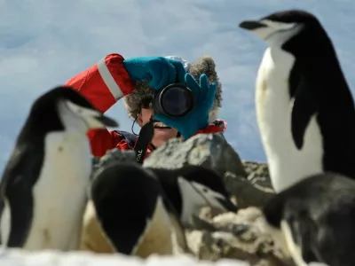 Oct 30, 2008 - Antarctica - Half Moon Island is a crescent-shaped islet that lies in the entrance to Moon Bay between Livingston and Greenwich Islands. It is home of the Argentine Teniente Camara Station. This beautiful location has Chinstrap penguin nests over majestic basaltic columns. Pictured: Tourist taking a photograph in a Chinstrap Penguin (Pygoscelis antarcticus) rookery.Model Released photo. (Credit Image: ? Kike Calvo/VW Pics/ZUMA Press)