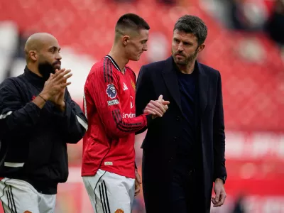 Manchester United's Benjamin Sesko shakes hands with coach Michael Carrick after the Premiier League soccer match between Manchester United and Crystal Palace in Manchester, England, Sunday, March 1, 2026. (AP Photo/Dave Thompson)