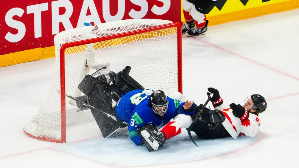 Canada's Emmitt Finnie, right, clashes against Slovenia's goaltender Zan Us during a preliminary round game between Canada and Slovenia at the men's ice hockey world championship in Fribourg, Switzerland, Friday May 22, 2026. (Salvatore Di Nolfi/Keystone via AP)