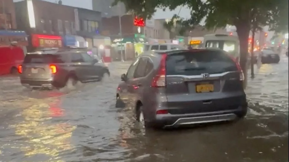 Vehicles travel through floodwaters following heavy rain in New York, U.S., May 20, 2026, in this still image obtained from social media video. Amun Zemi/via REUTERS THIS IMAGE HAS BEEN SUPPLIED BY A THIRD PARTY. MANDATORY CREDIT. NO RESALES. NO ARCHIVES. VERIFICATION: - Buildings, stoplights and road layout match satellite and archive imagery. - Coordinates: 40.708002, -73.800948. - Date was verified from metadata and weather reports of heavy raining in the area. / Foto: Amun Zemi