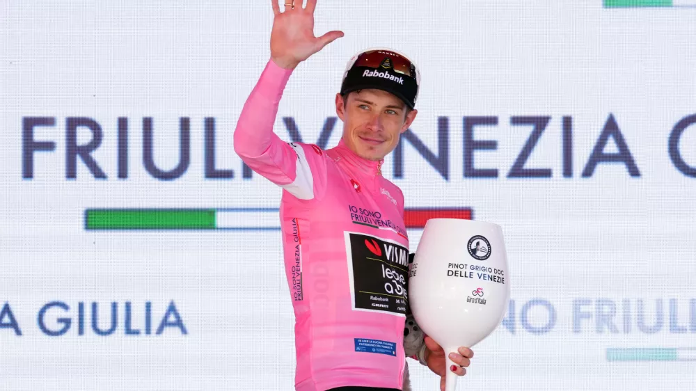 Denmark's Jonas Vingegaard wears the pink jersey of the race overall leader on the podium after winning the 14th stage of the Giro d'Italia cycling race, from Aosta to Pila, Italy, Saturday, May 23, 2026. (Gian Mattia d'Alberto /LaPresse via AP)
